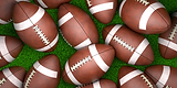 Multiple American footballs scattered on green turf