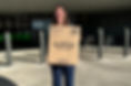 Woman holding a large box of Dollar Tree facial tissues outside a store
