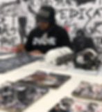Man in a Dior shirt signing football memorabilia.