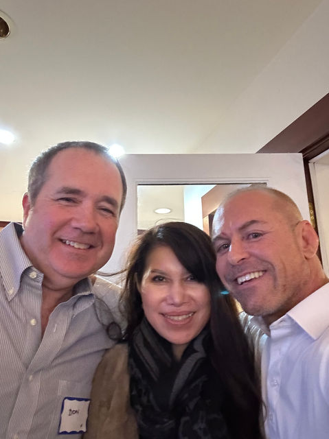 Three smiling colleagues at a business event