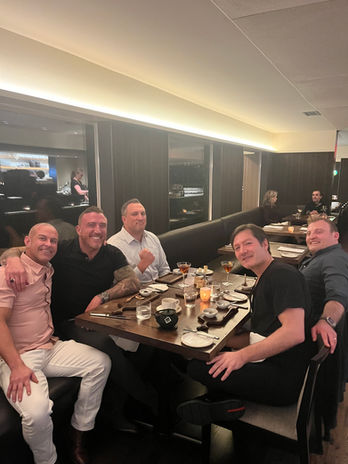 Six men smiling at a restaurant dinner