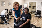 Physical therapist assists patient with arm exercise
