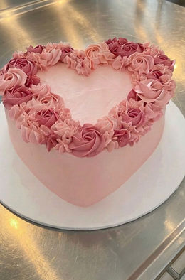 Pink Heart Cake covered in pink buttercream, topped with 2 tone pink pipework