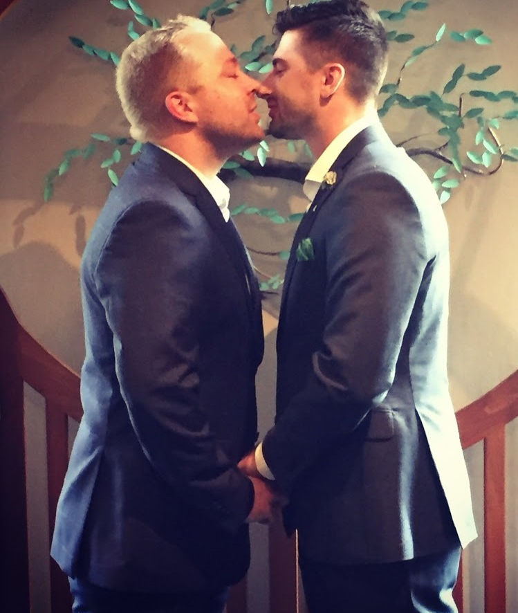 @mrdenniswest & @mrcodywest hodling hands and kissing during their wedding cerermony
