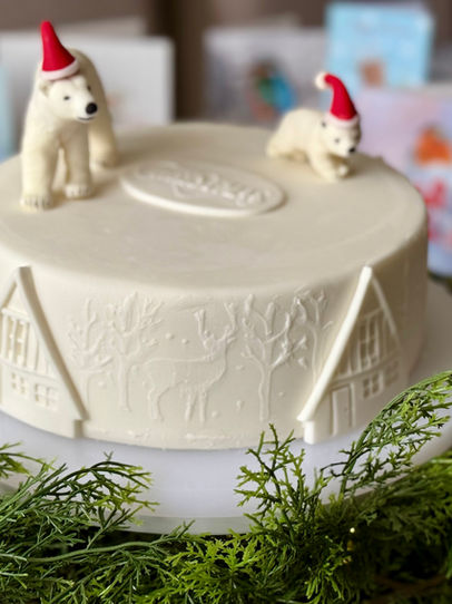Winter Resort  Christmas Cake with a Polar Bear mother and cub,  Deer and chalets on  a wintery landscape by Cakes by Rebecca Chipping Campden