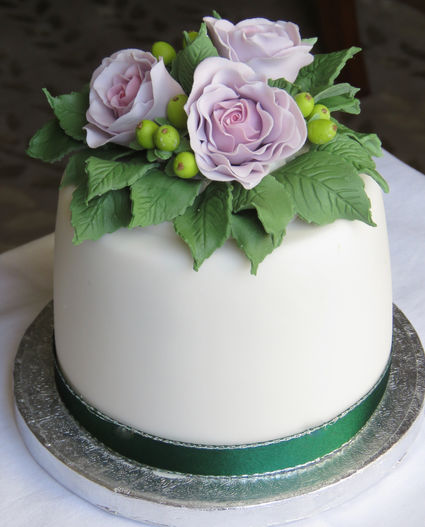 Small Christmas Holiday Cake Topped with Green Hypericum Berries and Lilac Cabbage Roses. Centre Piece Christmas Cake