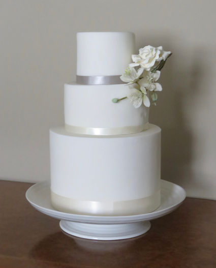 3 tier stark white wedding cake adorned with a White rose and nigella edible flower by cakes by Rebecca Chipping Campden