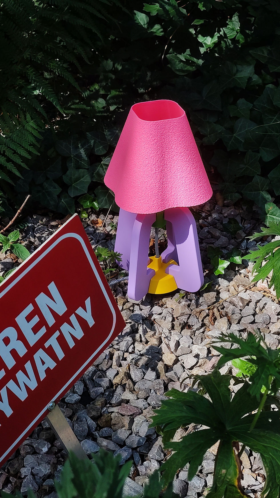 Pink and purple Yam Yest Design lamp in a garden setting