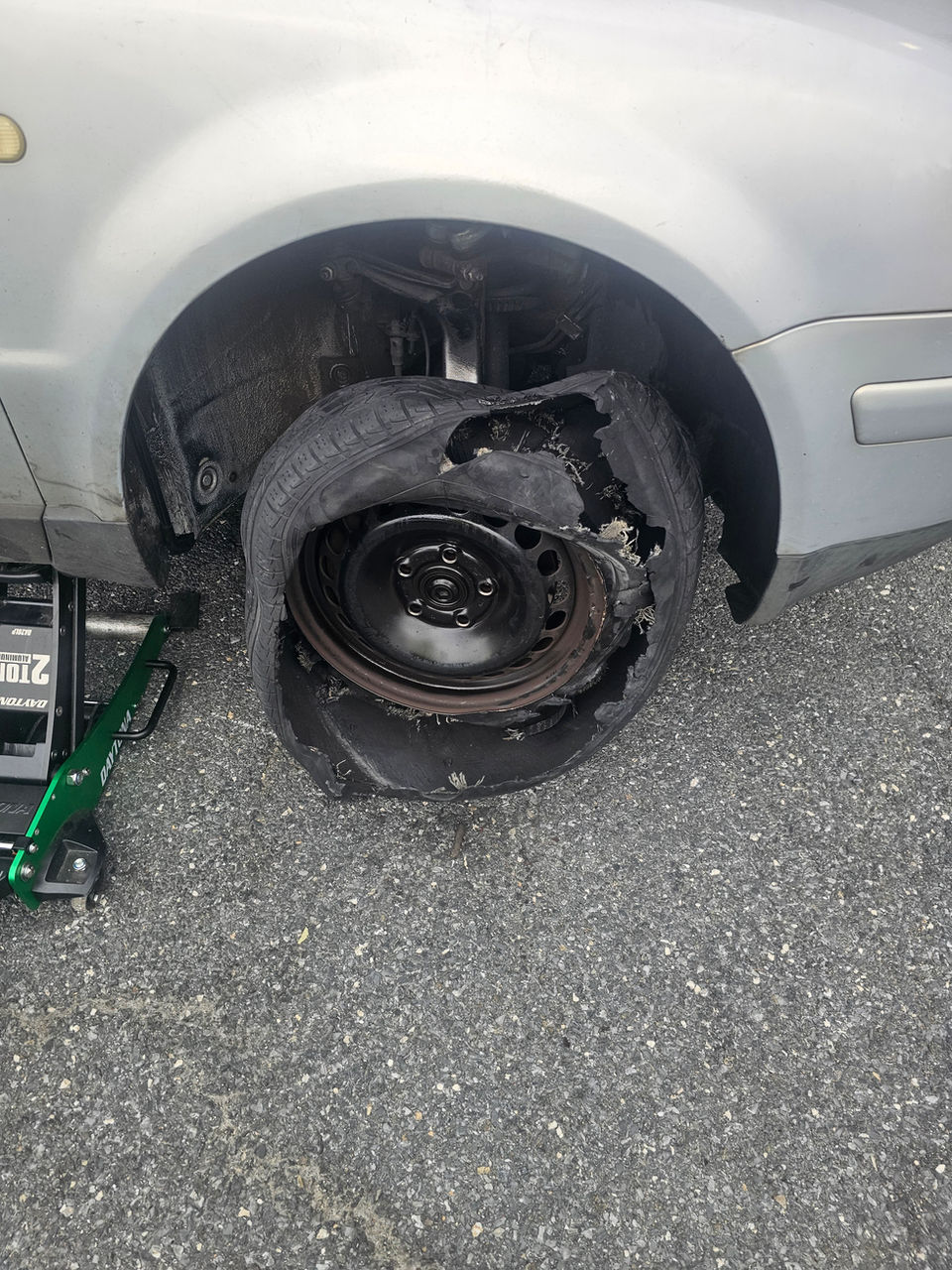 Technician completing a quick roadside tire change and spare tire installation on a flat wheel