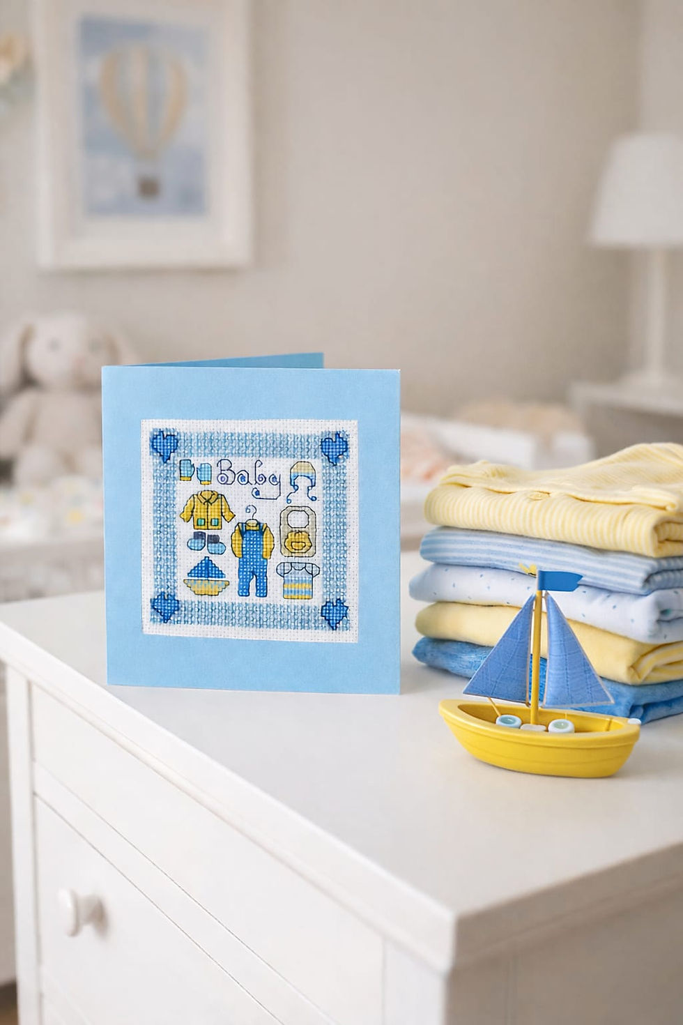handcrafted new baby card of collage of blue and yellow clothes and yacht