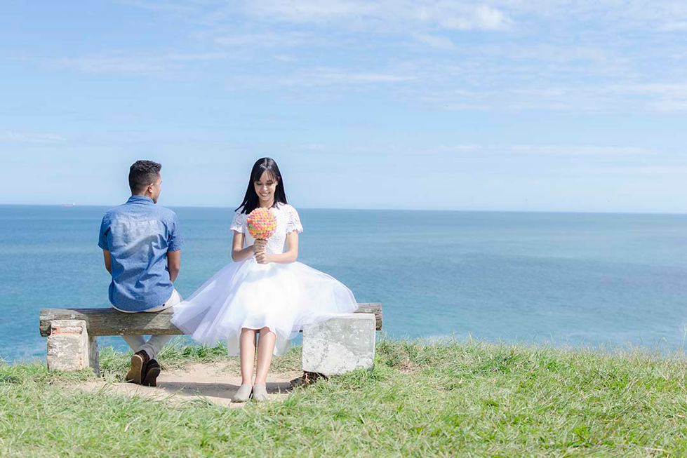 namorados sentados em banco no alto da montanha