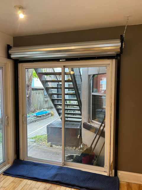 Roller fire shutter without it's hood installed infront of patio door, protecting fire ecape