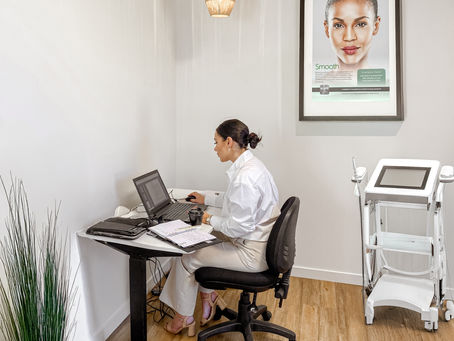 Allied health woman in consulting suite at desk with laptop