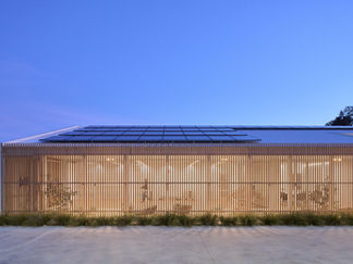 outside of The Centre consulting suite at night with dark blue sky, wooden cladding