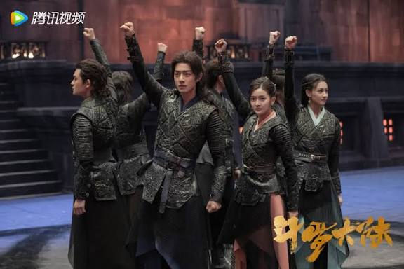 Douluo Continent cast in a still where they are wearing black tournament outfits and raising their fists in a circle