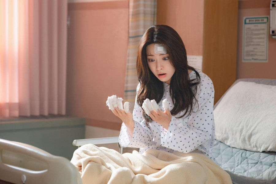 Ha Young as Go Eun-Sae looking at her bandaged fingers in the hospital in a still from the K-Drama Our Sticky Love