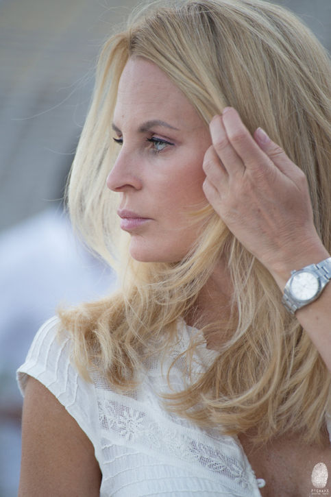 a woman wearing a silver watch adjusts her hair