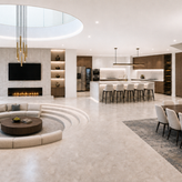 Modern luxury open-concept living room with circular sunken seating area, fireplace feature wall, kitchen island, and floating staircase.
