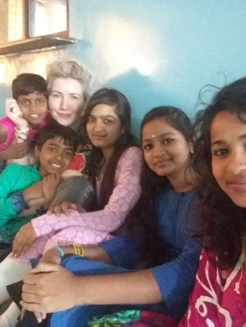 Children in Orphanage in Mysore India surrounding yoga teacher 
