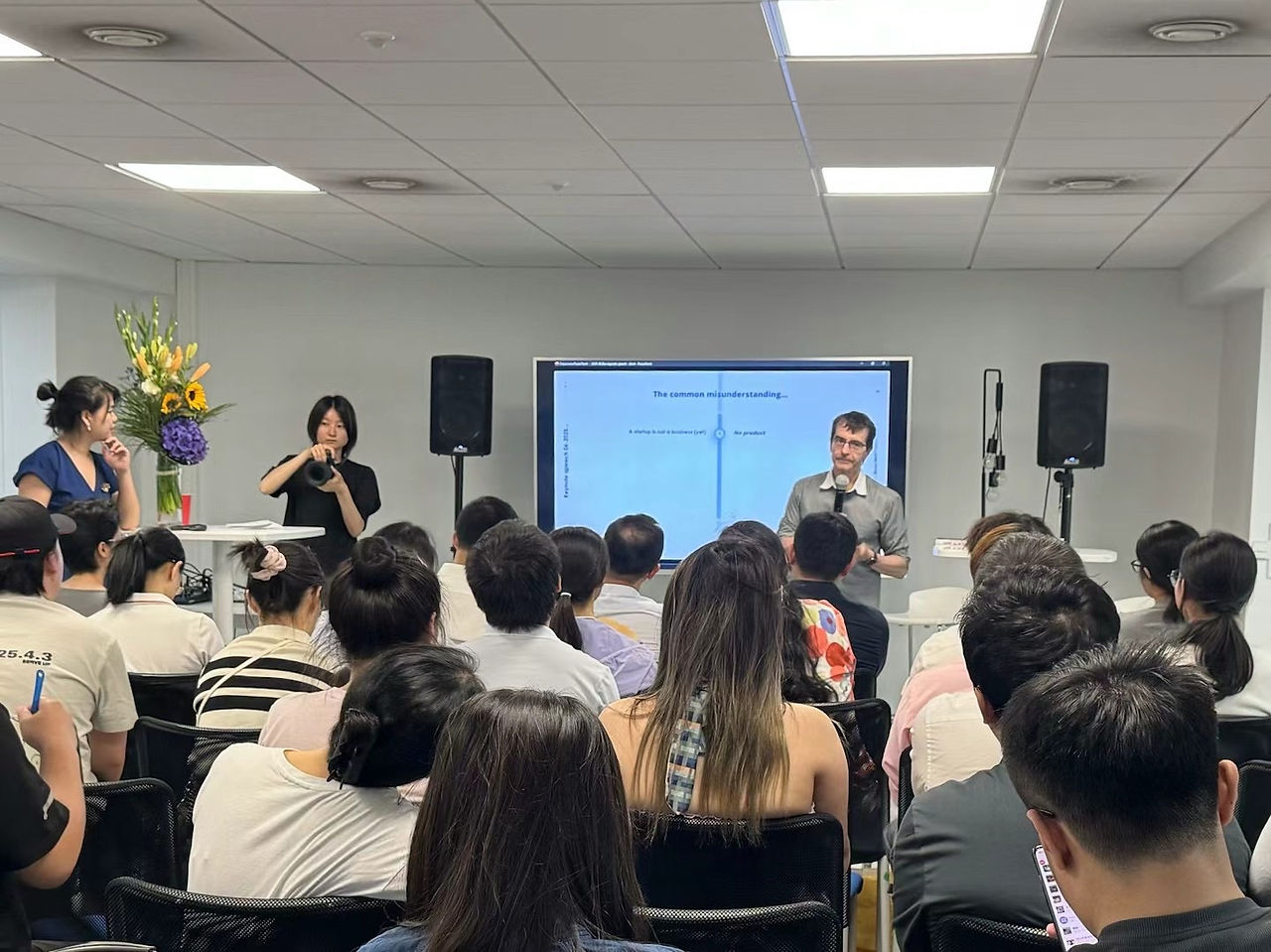 Chinese speaker presents competition policies and participation guidelines to French and European attendees at the Belt and Road postdoctoral event in Paris.