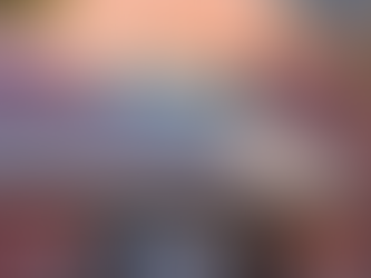 A brick building with large windows and a curved sign that reads USC Suzanne Dworak Peck School of Social Work. Sunlight and tree shadows fall across the building’s exterior.