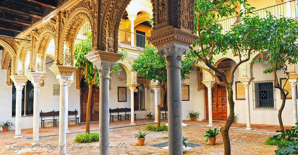 Modern interior with a sleek white hanging lamp, round table, and chairs. White cabinets and artwork in the background create a minimalistic feel.