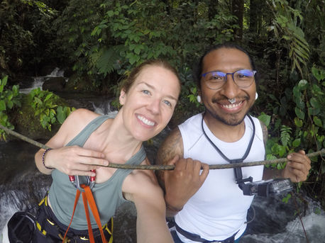 A man and woman are posing for a picture before rapelling.
