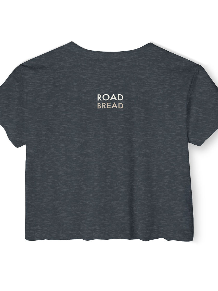 A heather blue crop top back view with small Road Bread logo at the neck.