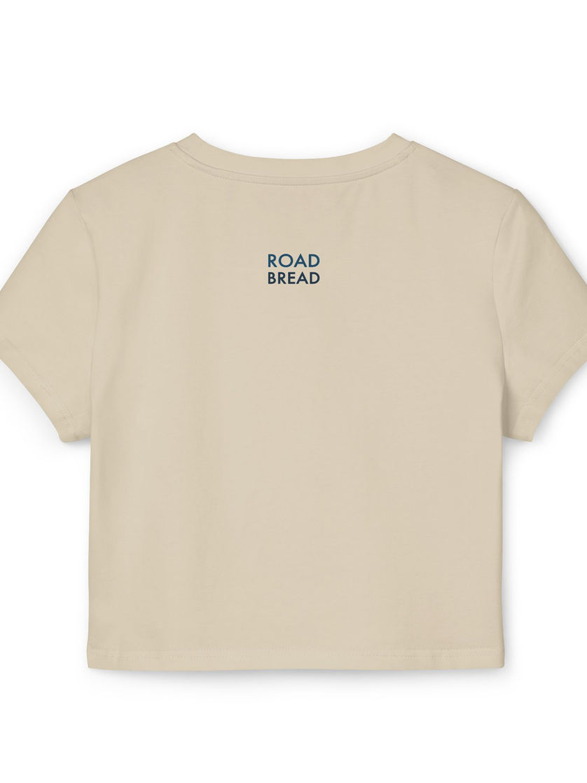 Back view of beige baby tee with subtle ROAD BREAD branding