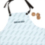 Close-up overhead view of folded baguette print apron with black straps beside a stack of chocolate-chip cookies