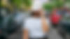 Woman standing in the middle of the street with a white Road Bread Hat and a light blue pa