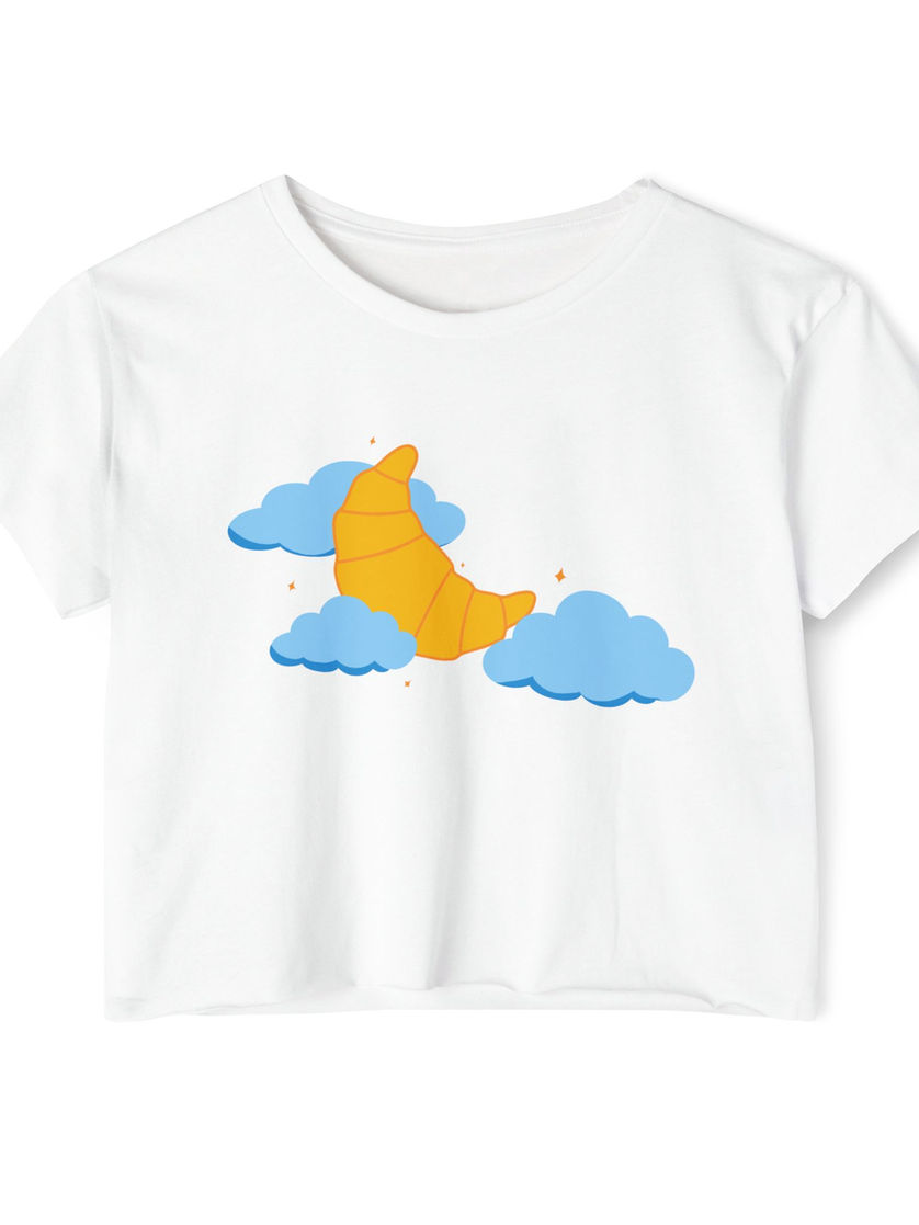 A white cropped t-shirt featuring a yellow croissant shaped like a crescent moon floating between fluffy blue clouds.