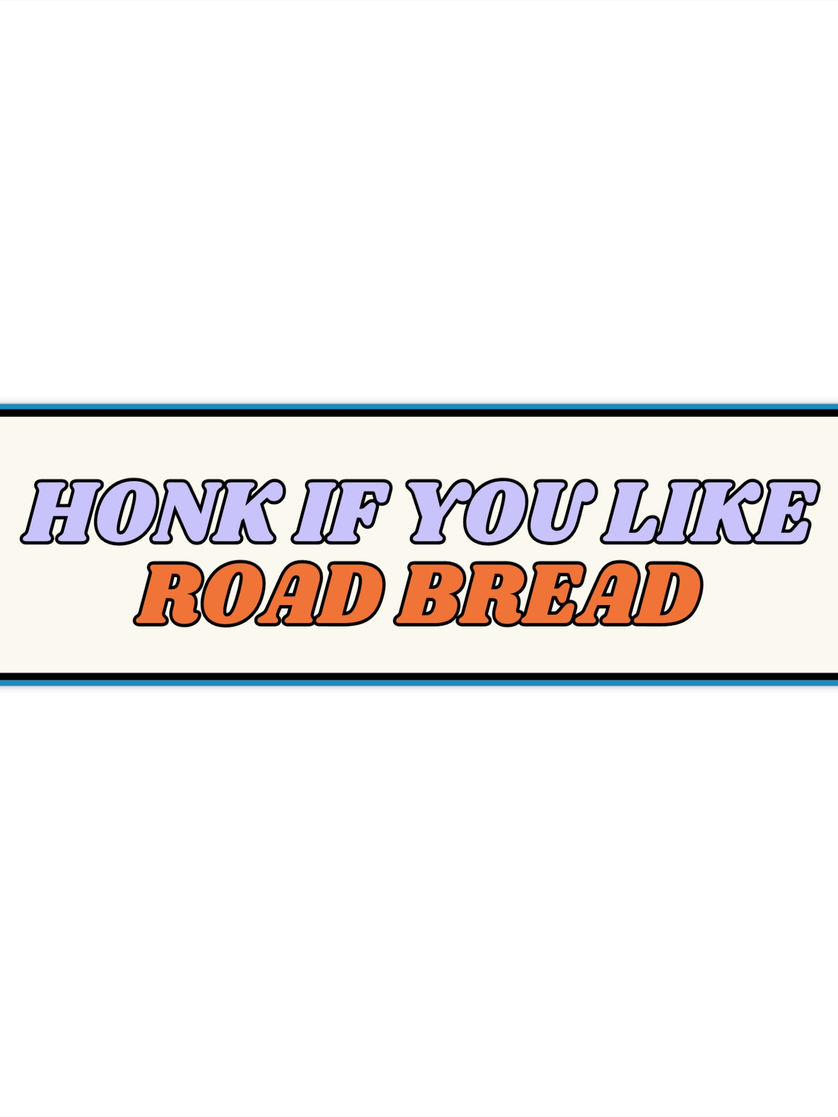 Rectangular cream bumper sticker with purple “HONK IF YOU LIKE” text above orange “ROAD BREAD,” blue outline border.
