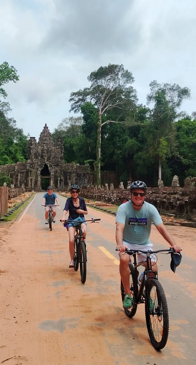 People on bike tours near Angkor Wat temple gate