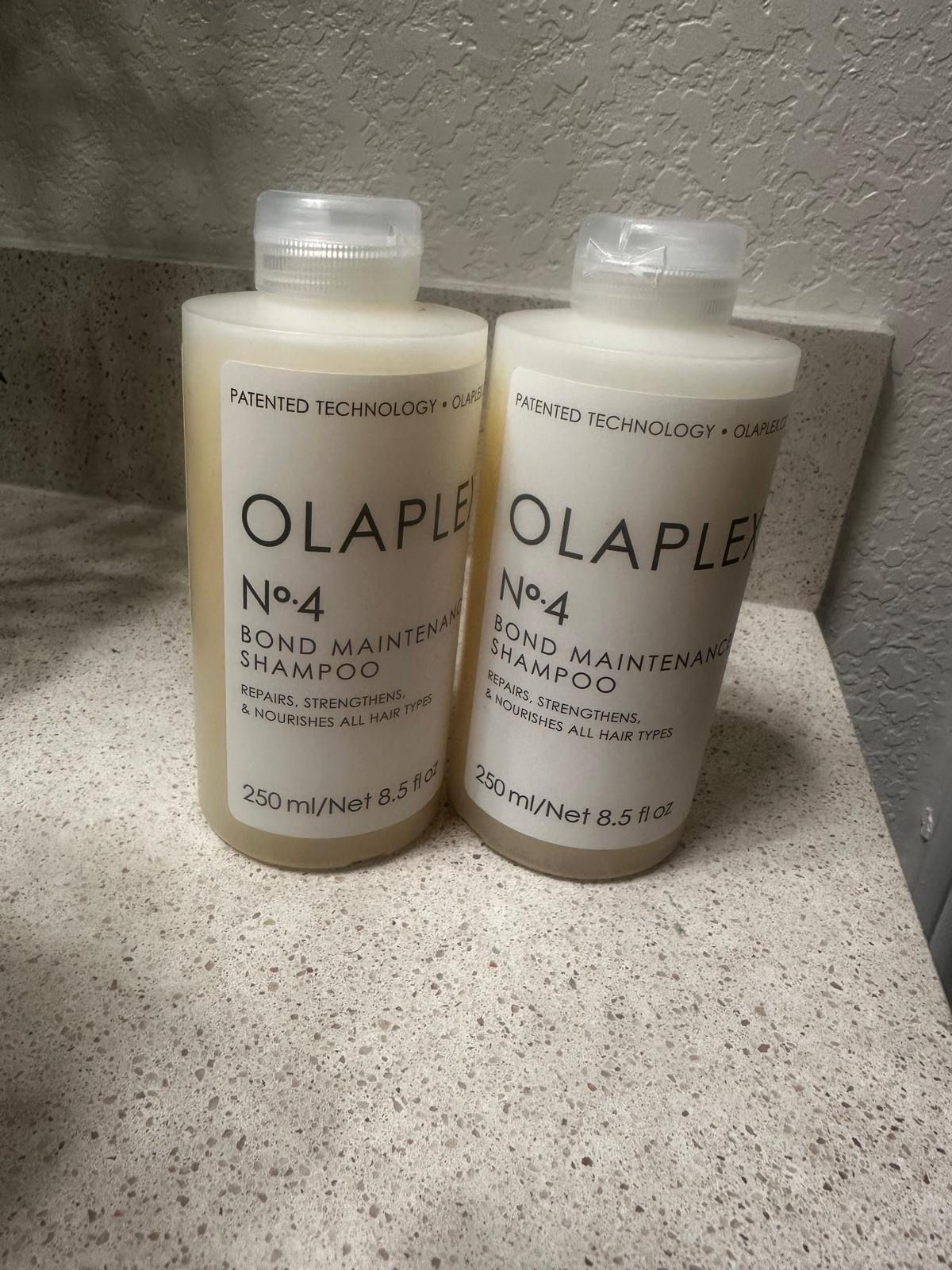 Two Olaplex No.4 Bond Maintenance Shampoo bottles on a counter.