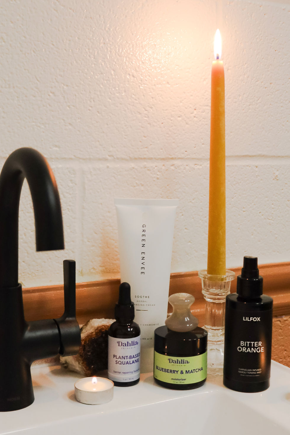 a bottle of green enee sits next to a bottle of bitter orange
