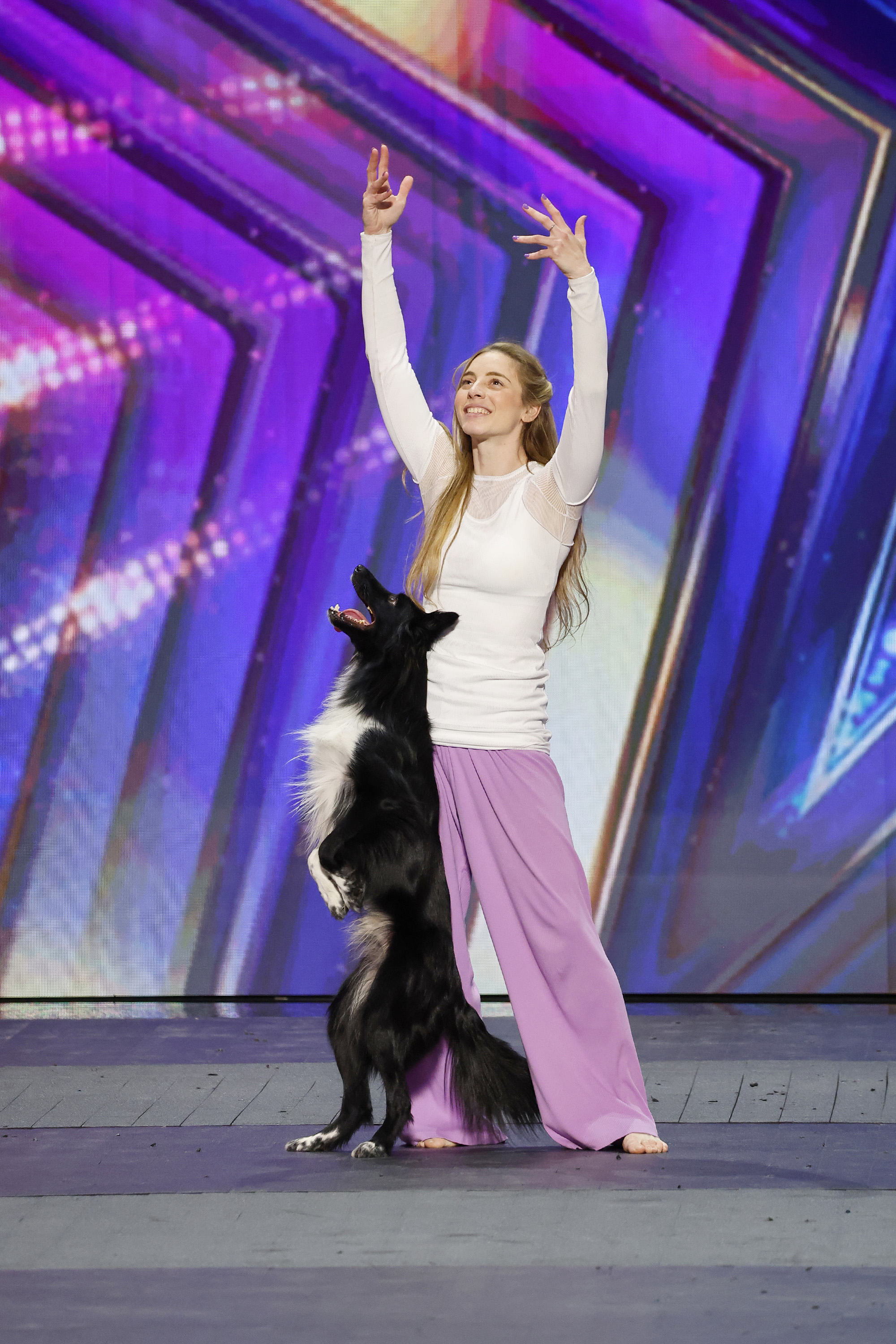 A handler and dog performing advanced styling movements in a training ring