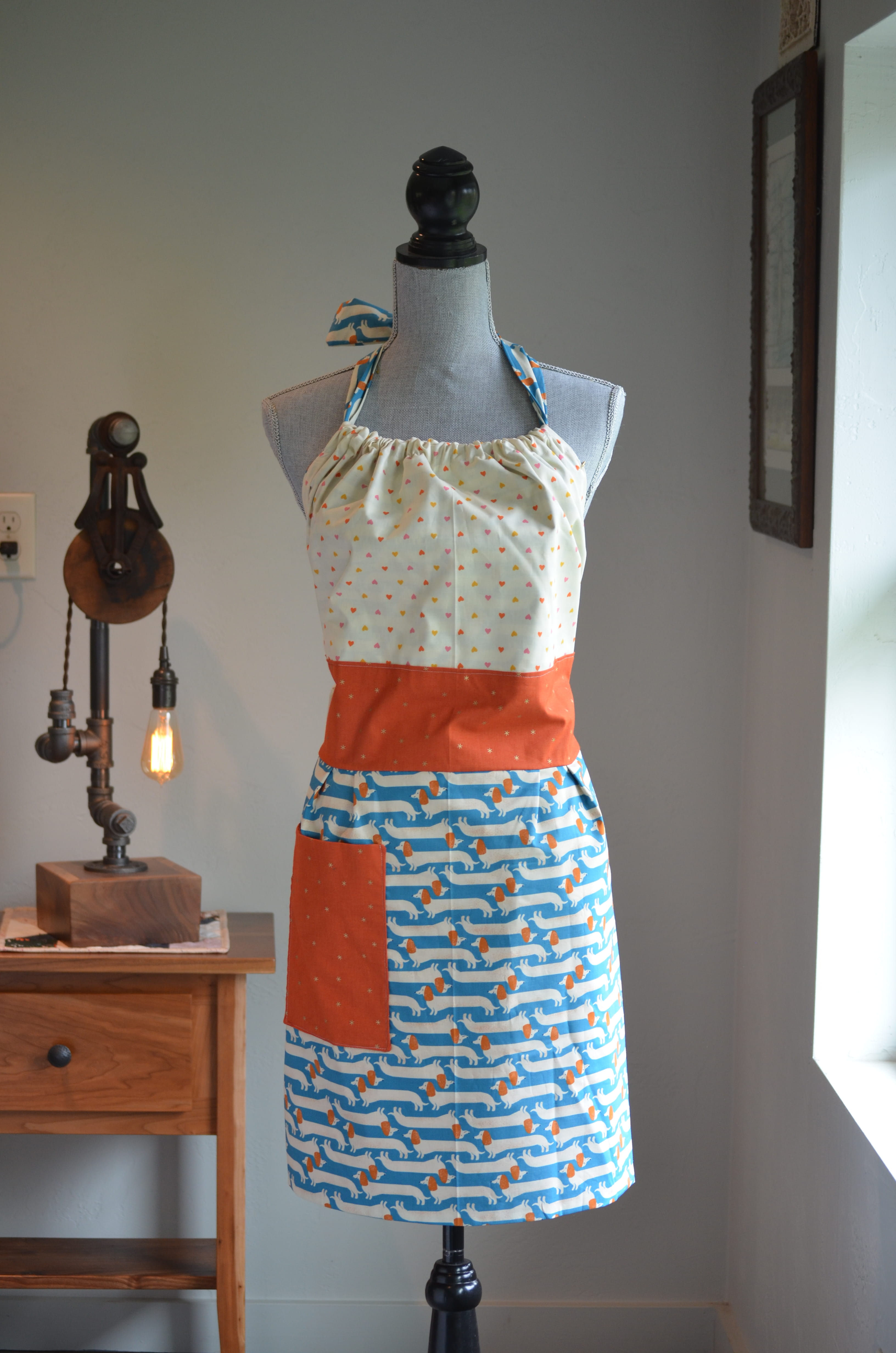 Reversible Apron with Cream colored top and blue with wiener dogs on bottom