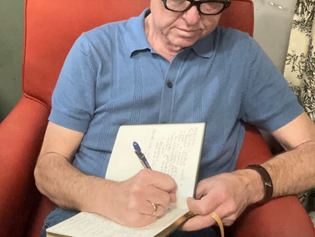 Small business owner journaling in a comfortable chair at The Vintage Nest Home & Gifts, capturing ideas and inspiration during a peaceful morning work session.