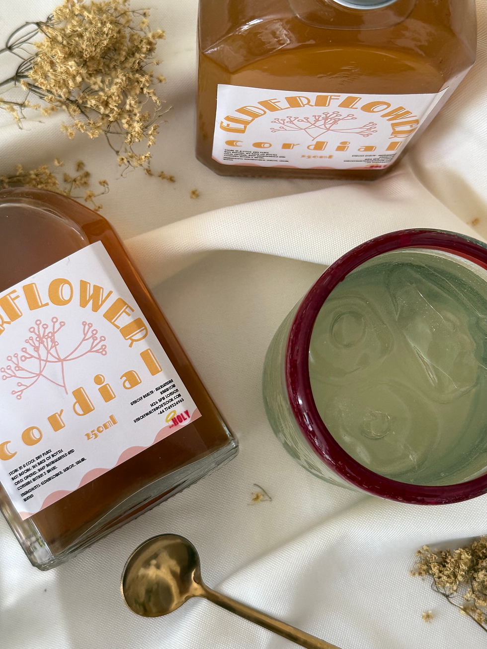 a bottle with amber liquid flat on white background and the same bottle standing next to it, both bottles have white label