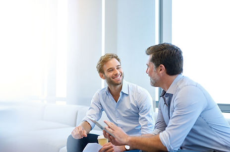 Smiling young businessman enjoying a positive conversation with a mature business partner