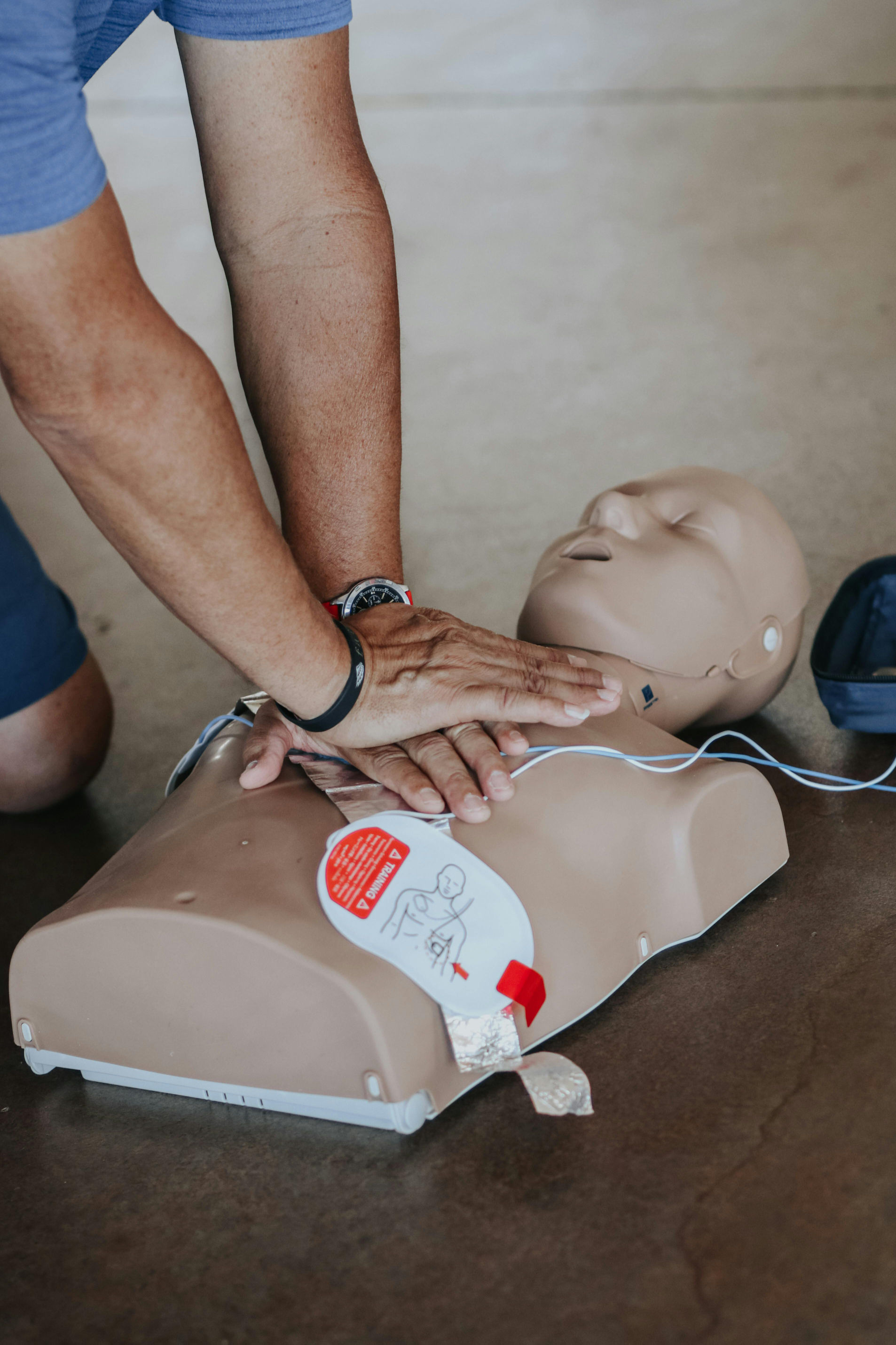 A student performing cpr on a mannequin.