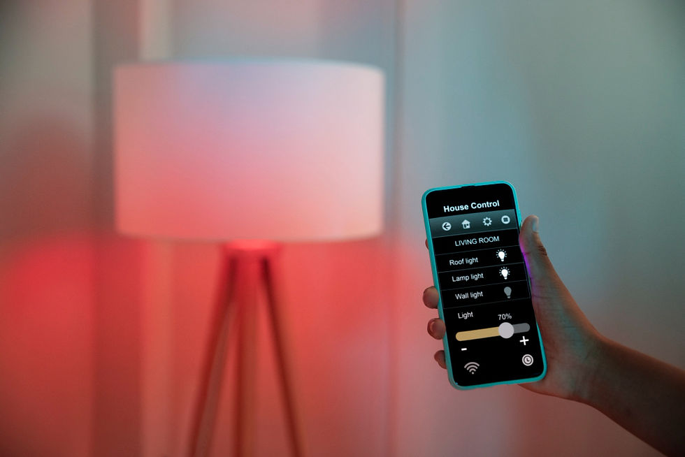 Mão segura celular com app House Control ajustando luzes da sala; abajur ao fundo com brilho vermelho e clima moderno.