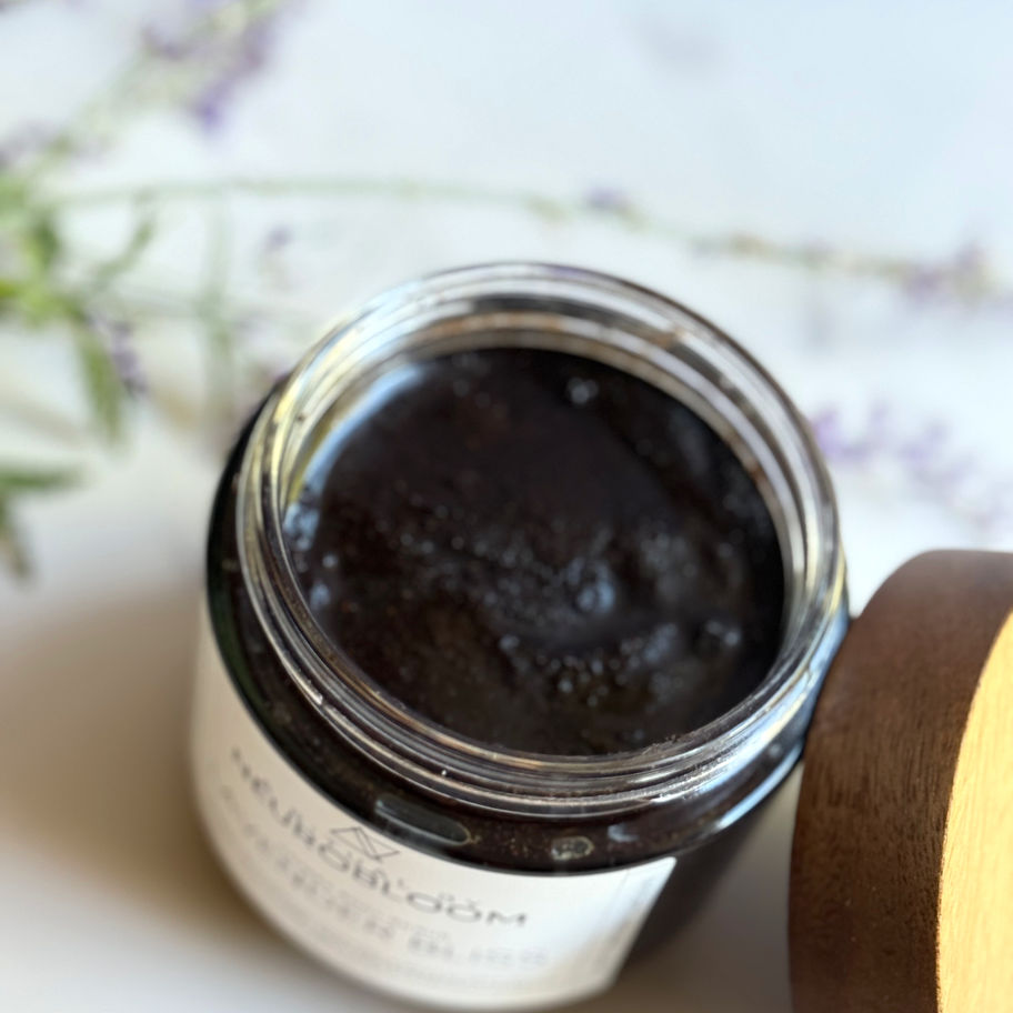 Close-up of coffee scrub granules with visible coffee grounds and lavender for gentle exfoliation and hydration