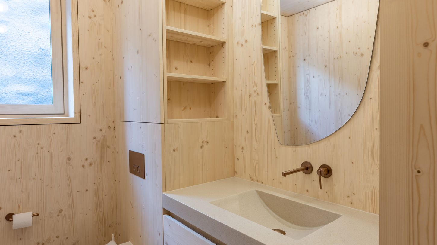 Kleines Badezimmer mit WC und massgefertigten Holzeinbauten für Stauraum