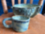 Handmade coastal pottery mug and bowl set on a wooden chair.