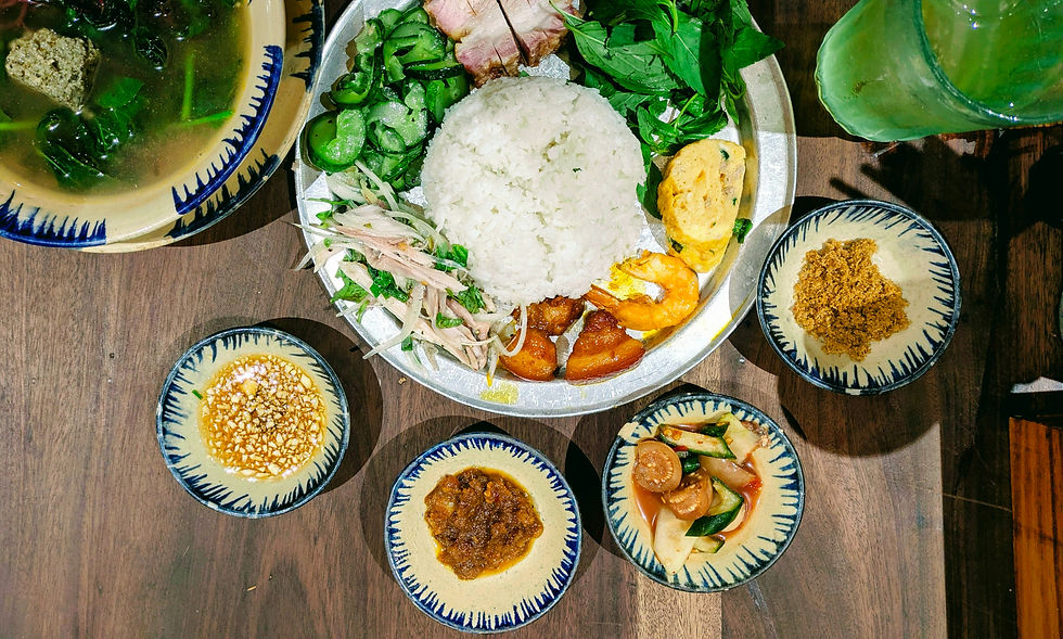 A typical rice plate in Hue, Vietnam with a spread of small dishes.