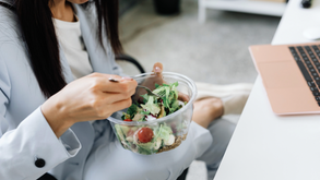 A woman eating a salad while working