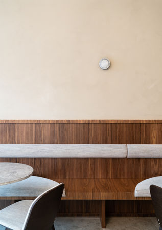 Sfeervol interieur van een ijssalon met warme materialen, zitbanken en indirecte verlichting.