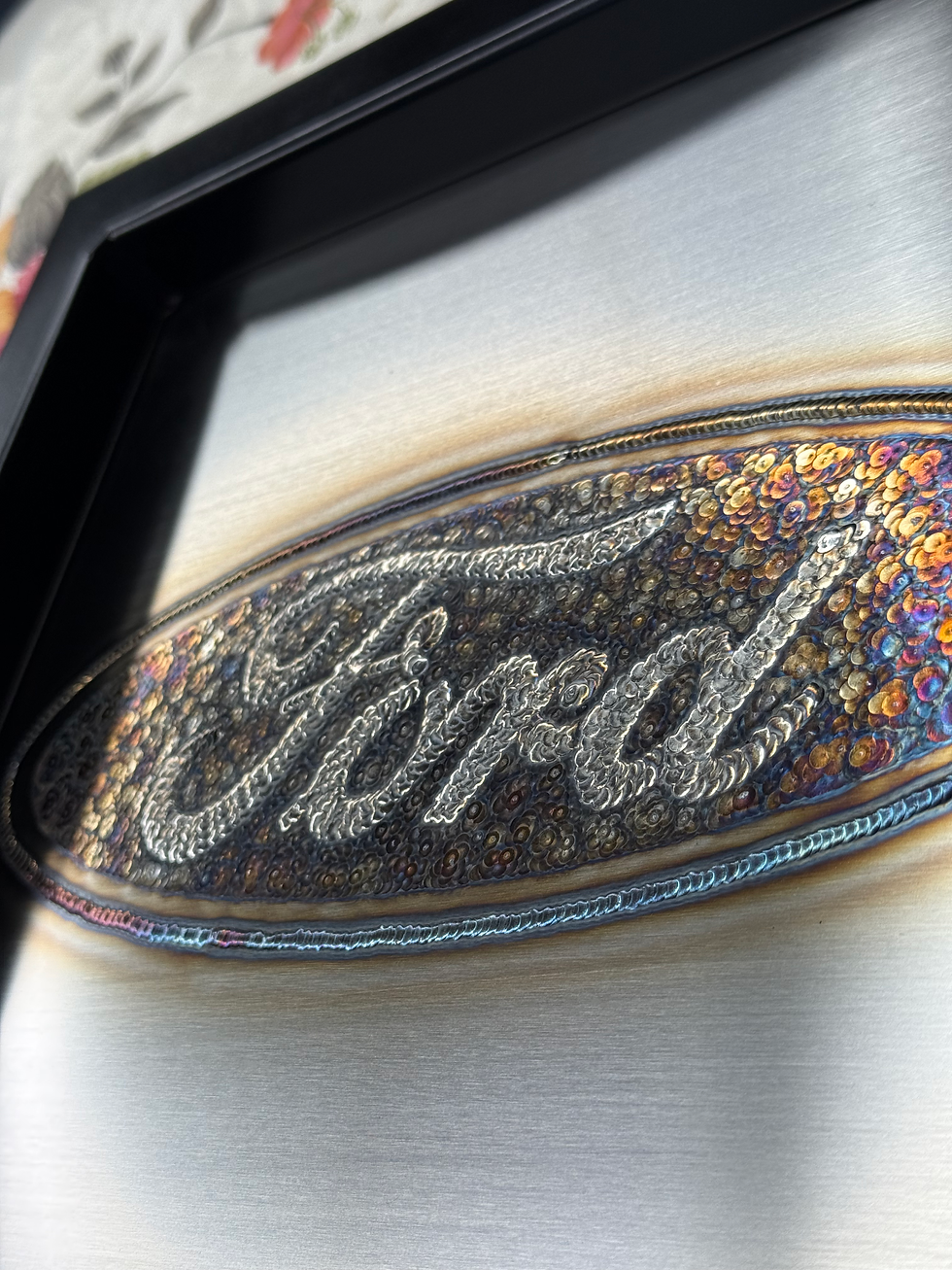 Thumbnail: colorful Ford logo in tig weld art framed in black painted tubing right side view
